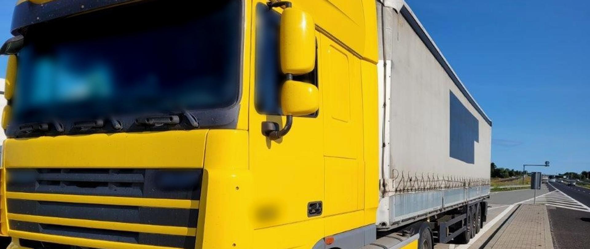 Od lewej: ciągnik siodłowy z podpiętą naczepą typu firanka stoi w wyznaczonej zatoce kontrolnej przy ekspresowej „siódemce”.