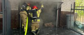 Strażacy otwierają drzwi wejściowe do garażu