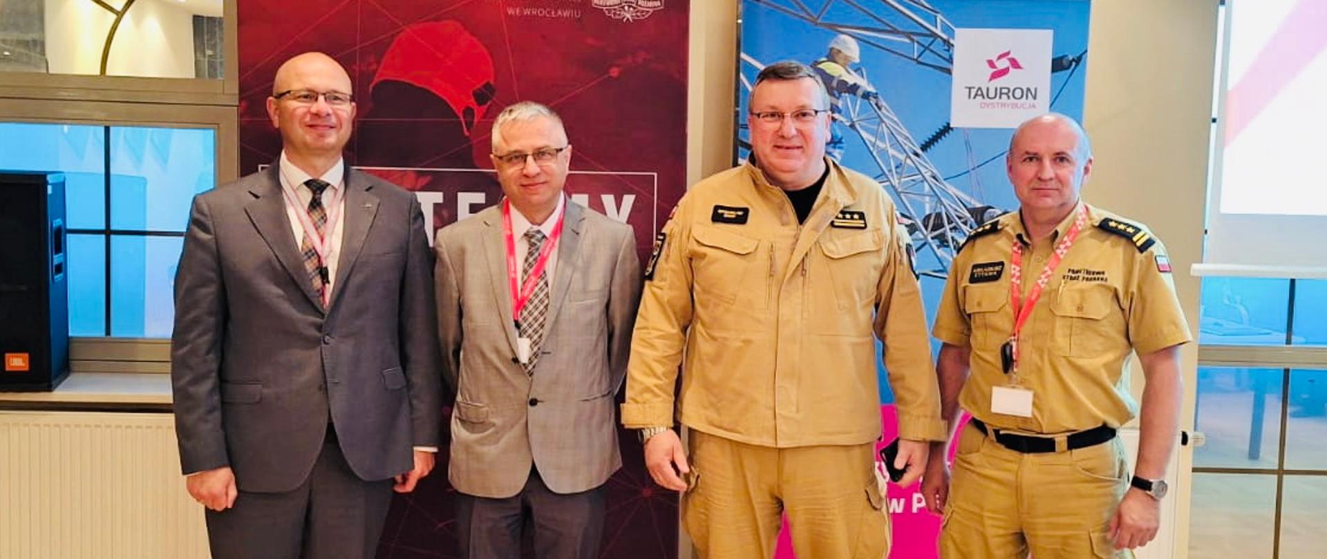 dwóch strażaków na stanowiskach kierowniczych wraz z przedstawicielami firmy Tauron