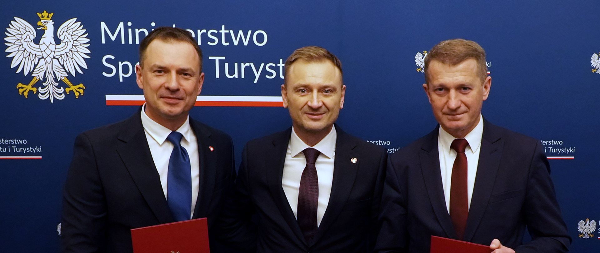 Powołanie wiceministrów w Ministerstwie Sportu i Turystyki - na zdjęciu od lewej stoją na tle ścianki z logo ministerstwa wiceminister Piotr Borys, minister Sławomir Nitras i wiceminister Ireneusz Raś