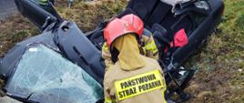 Strażacy obok rozbitego samochodu