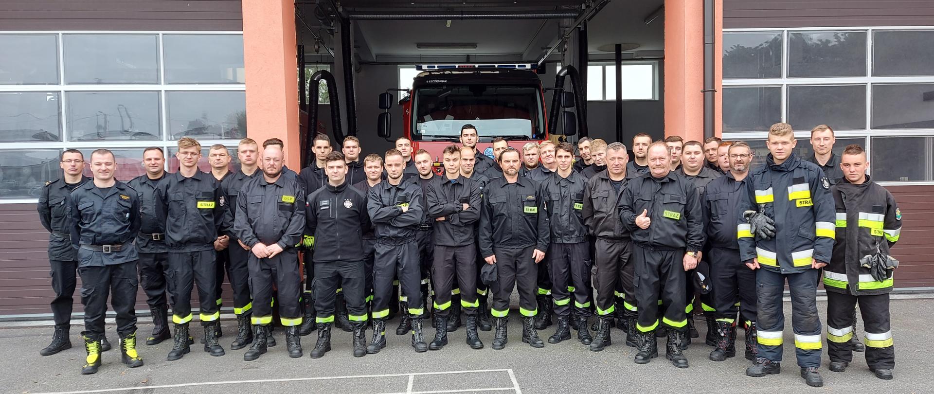 Zdjęcie grupowe strażaków uczestniczących w egzaminie na szkoleniu. 