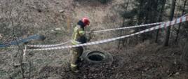 Na zdjęciu strażak nad zabezpieczoną studzienką 
