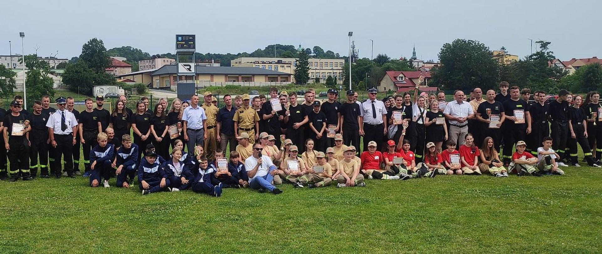 Zdjęcie przedstawia ustawienie się drużyn po wręczeniu nagród rzeczowych na zakończenie zawodów sportowo- pożarniczych