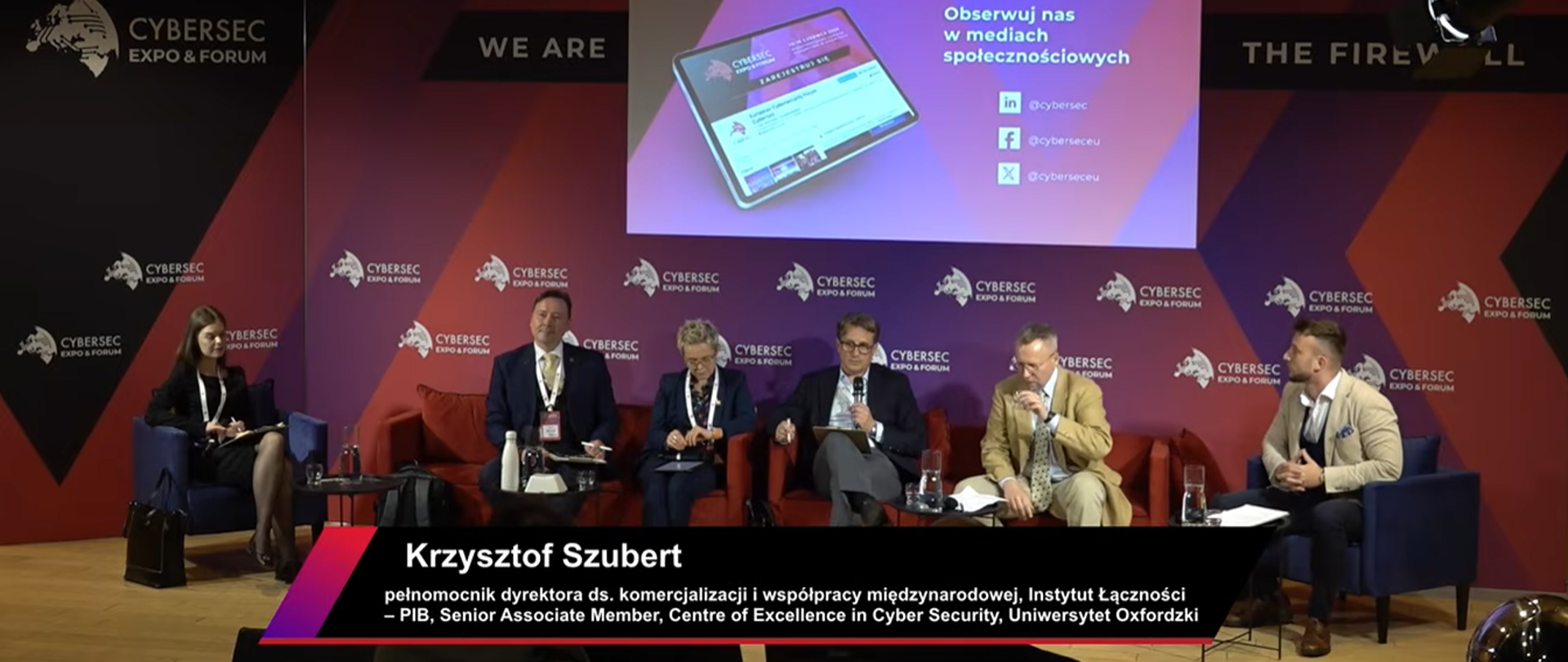 Paneliści podczas debaty, przy mikrofonie Krzysztof Szubert