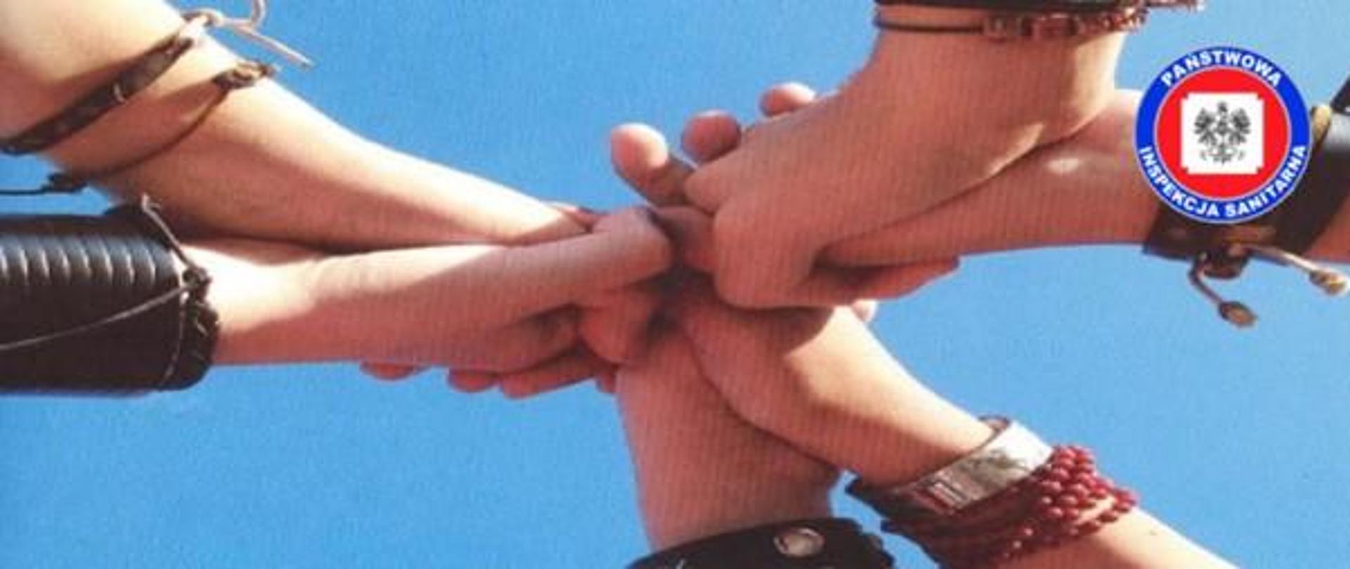 Zdjęcie przedstawia splecione ręce na znak współpracy przy realizacji programu „Znajdź właściwe rozwiązanie”. W prawym górnym rogu znajduje się logo Państwowej Inspekcji Sanitarnej.