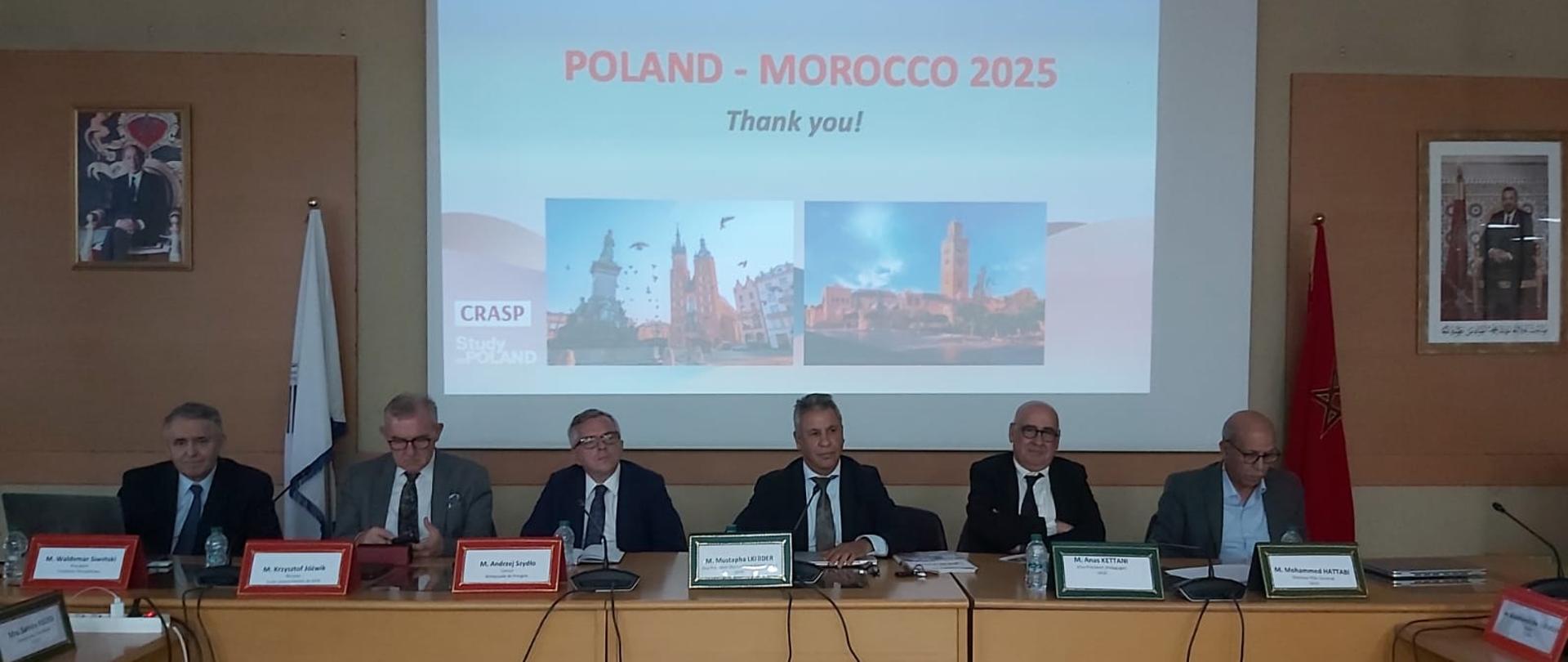 6 personnes en costume assises derrière une table de conférence