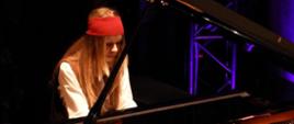 Zdjęcie kolorowe. Nastolatka w stroju piratki gra na fortepianie. 