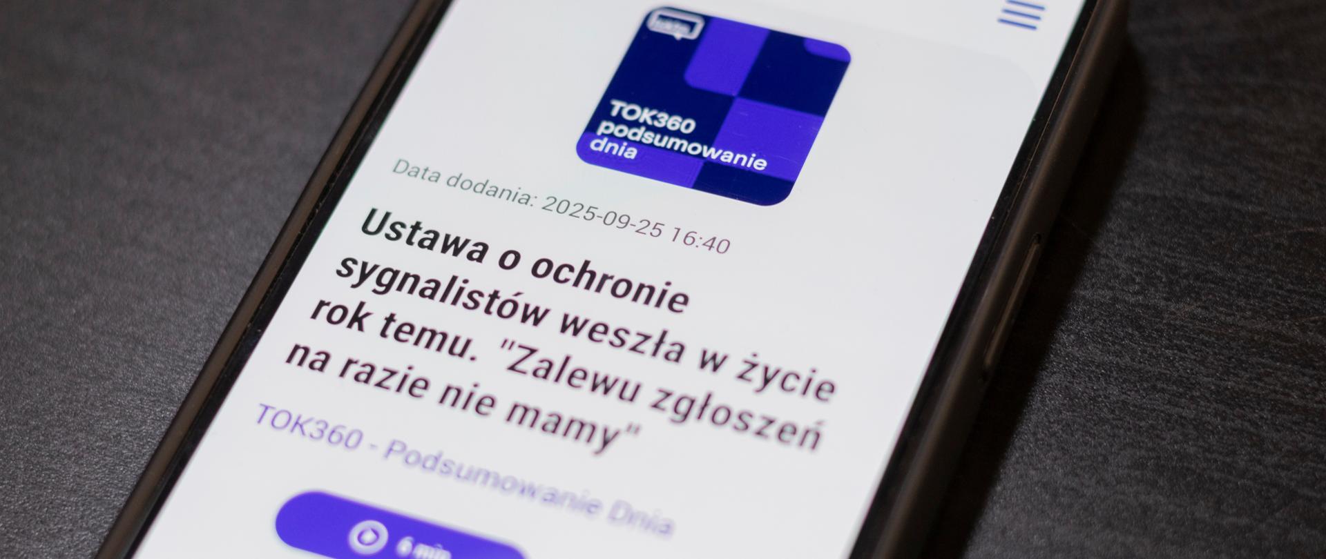 Zdjęcie telefonu, na którym wyświetla się strona z podkastem. Na stronie jest duży tytuł "Ustawa o ochronie sygnalistów weszła w życie rok temu. Zalewu zgłoszeń na razie nie mamy"