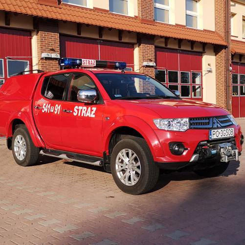 Na zdjęciu lekki samochód specjalny rozpoznawczo-ratowniczy na placu manewrowym przed garażami Jednostki Ratowniczo-Gaśniczej