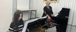 Zajęcia z uczennicą przy fortepianie - prowadząca siedzi przy drugim instrumencie