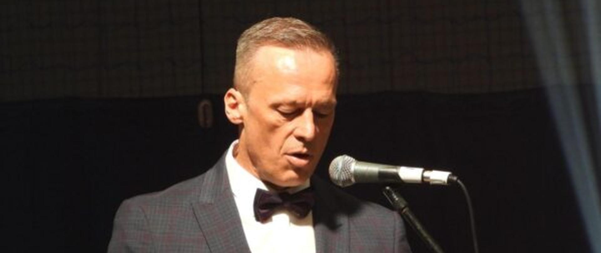 Dyrektor szkoły przemawia przy mównicy.