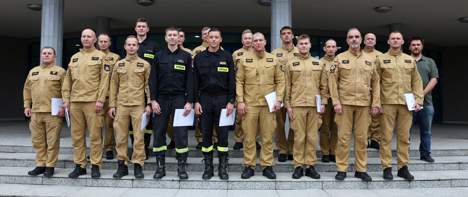 Pamiątkowe zdjęcie grupowe funkcjonariuszy PSP będących uczestnikami szkolenia "Prąd elektryczny, a zagrożenia dla strażaków" w towarzystwie Zastępcy Komendanta Szkoły, funkcjonariusza CS PSP oraz mężczyzny