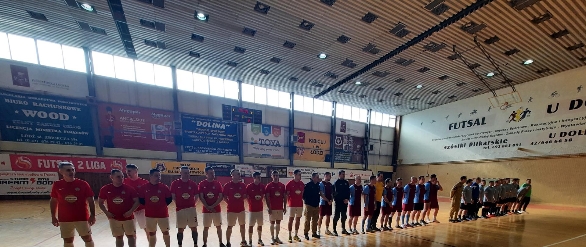 Zawodnicy zwycięskich drużyn stojący w rzędzie w oczekiwaniu na wręczenie nagród