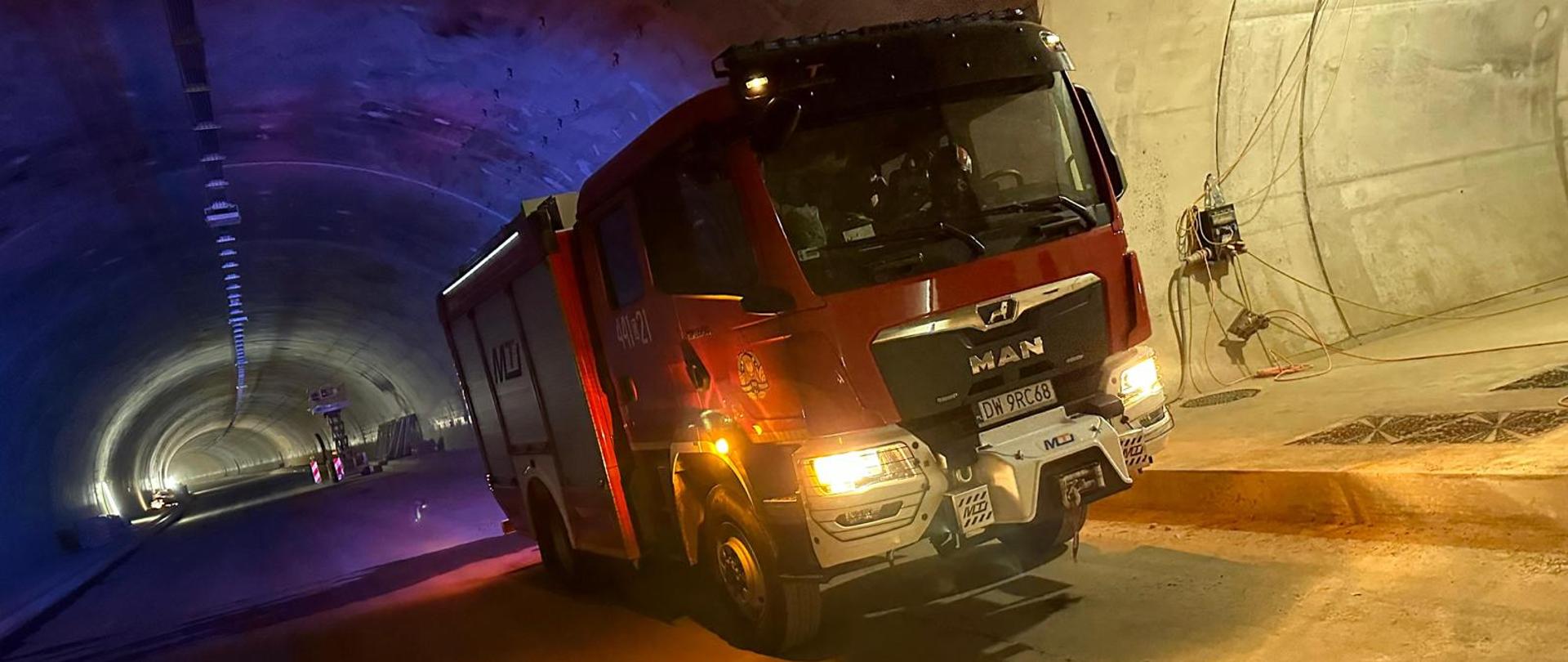 Obraz przedstawia samochód pożarniczy w budowanym tunelu na drodze S3