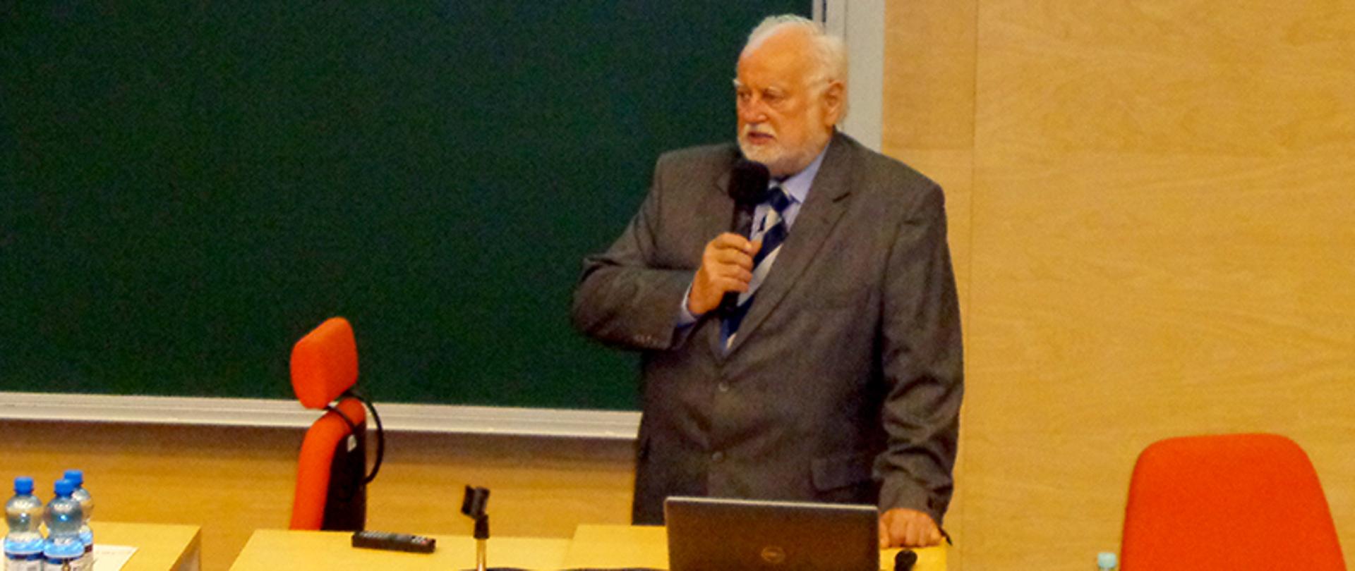 Mężczyzna z mikrofonem przed nim laptop