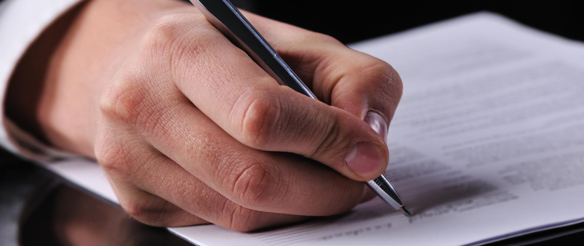 businessman writing on a form 