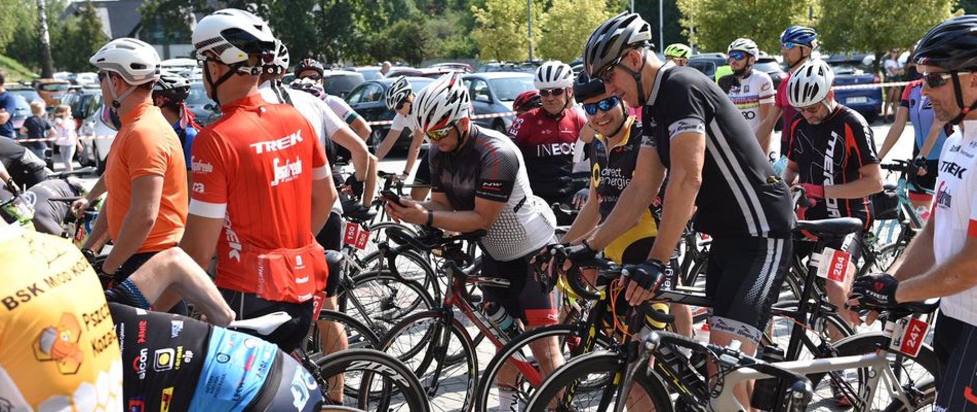 Zdjęcie przedstawia peleton kolarski przygotowujący się do startu w wspólnego na placu Miejskiego Ośrodka Sportu i Rekreacji w Łańcucie.