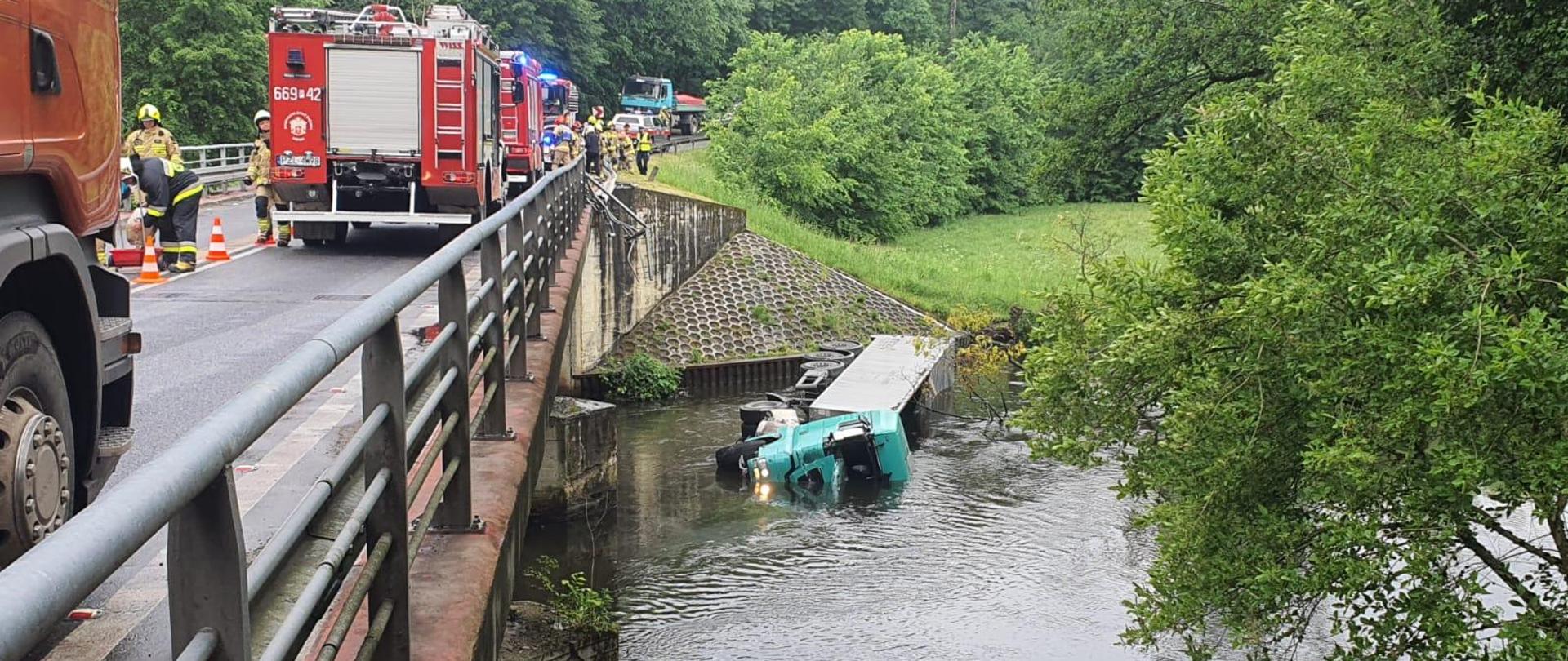 Zestaw pojazdów ciężarowych w korycie rzeki Gwdy