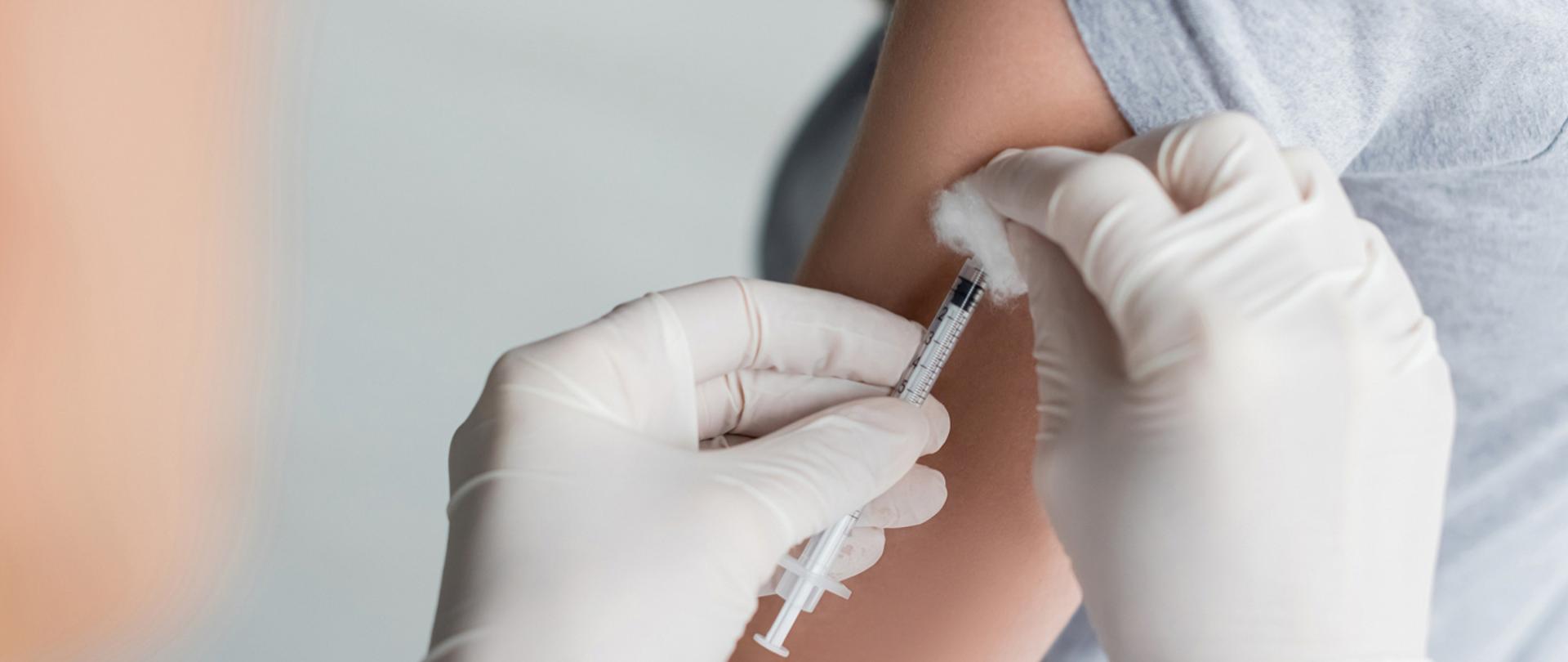 Na zdjęciu widoczne jest szczepienie pacjenta przed medyka.