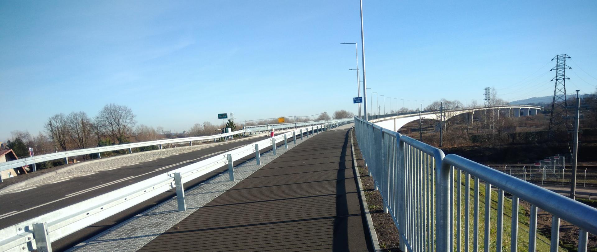 Nowy most na Dunajcu w Małopolsce, widok na chodnik i jezdnię z barierkami ochronnymi.