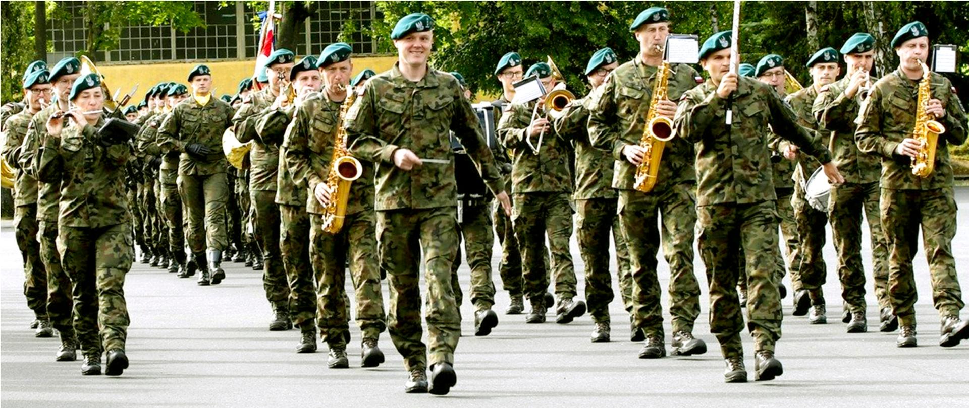 Zdjęcie przedstawia maszerującą orkiestrę wojskową
