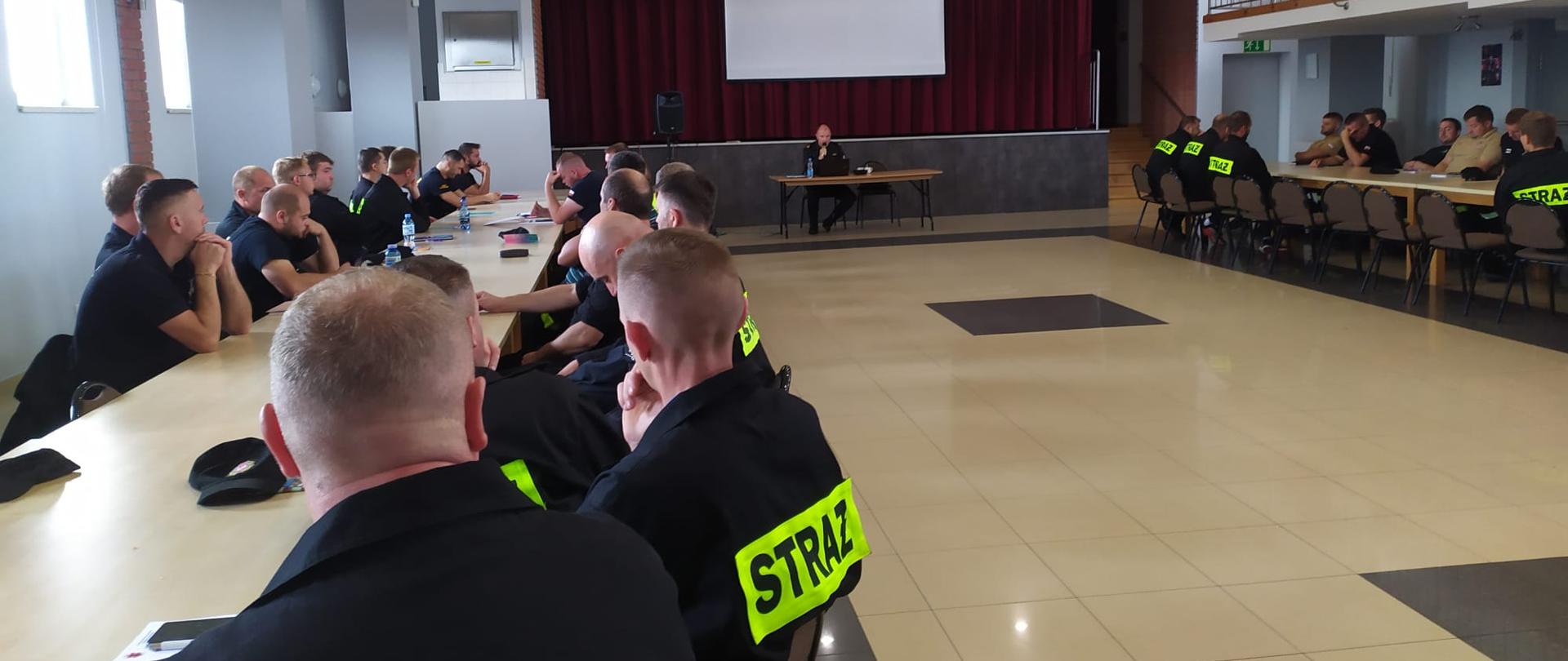 Druhowie OSP siedzą na sali podczas szkolenia BHP