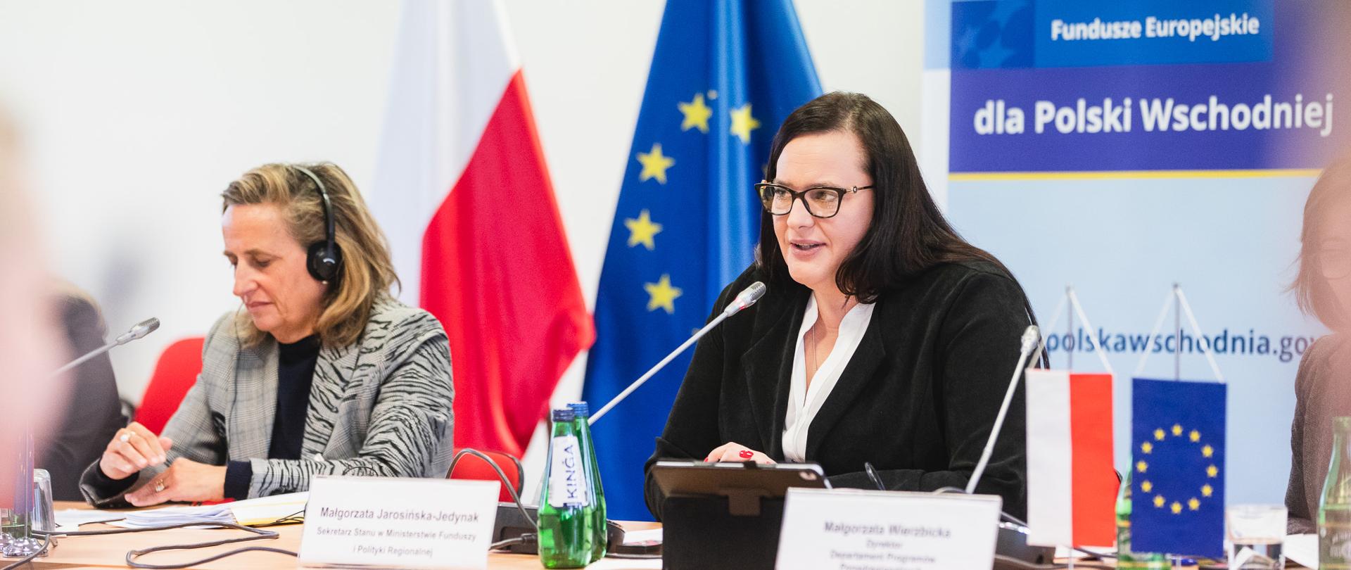Dwie osoby siedzą przy stole. Druga z lewej to wiceminister Małgorzata Jarosińska-Jedynak.