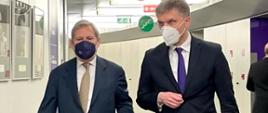 Minister rozwoju i technologii Piotr Nowak idzie korytarzem, po jego lewej stronie komisarz Johannes Hahn