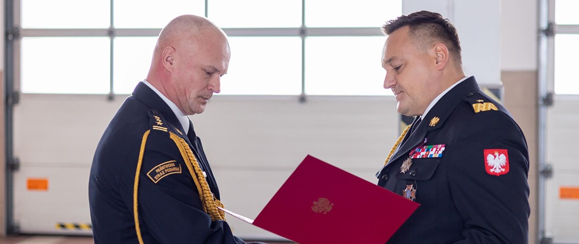 Funkcjonariusze straży podczas przekazania dokumentów 