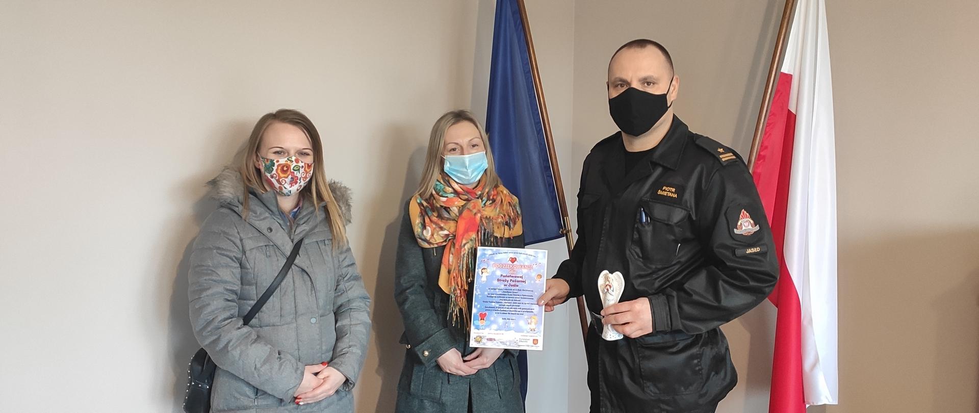 Na zdjęciu komendant powiatowy Państwowej Straży Pożarnej w Jaśle starszy brygadier Piotr Śmietana wraz z dwiema organizatorkami akcji charytatywnej, komendant trzyma podziękowania 