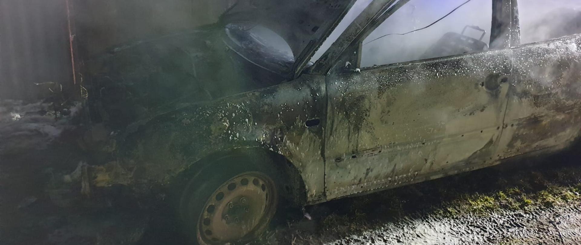 Spalone auto osobowe. Otwarta maska. Dużo dymu.