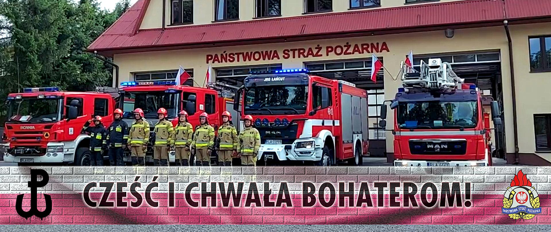 Na zdjęciu ośmiu strażakach w ubraniach specjalnych stoi w szeregu. Za nimi ustawione samochody pożarnicze.Nad samochodami, na ścianie budynku napis Państwowa Straż Pożarna. Na dole zdjęcia biało czerwona wstęga z symbolem Polski Walczącej , logo PSP oraz napisem Cześć i chwała bohaterom!