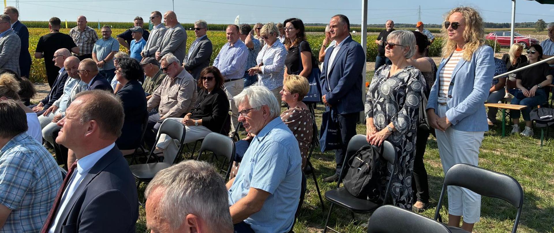 Uczestnicy siedzący i stojący na polu podczas Krajowego Dnia Soi w Sulejowie