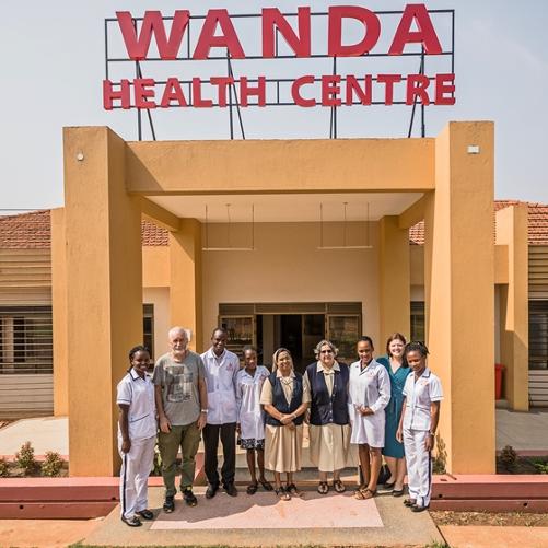 Personel medyczny i inne osoby zaangażowane w budowę szpitala przed budynkiem 