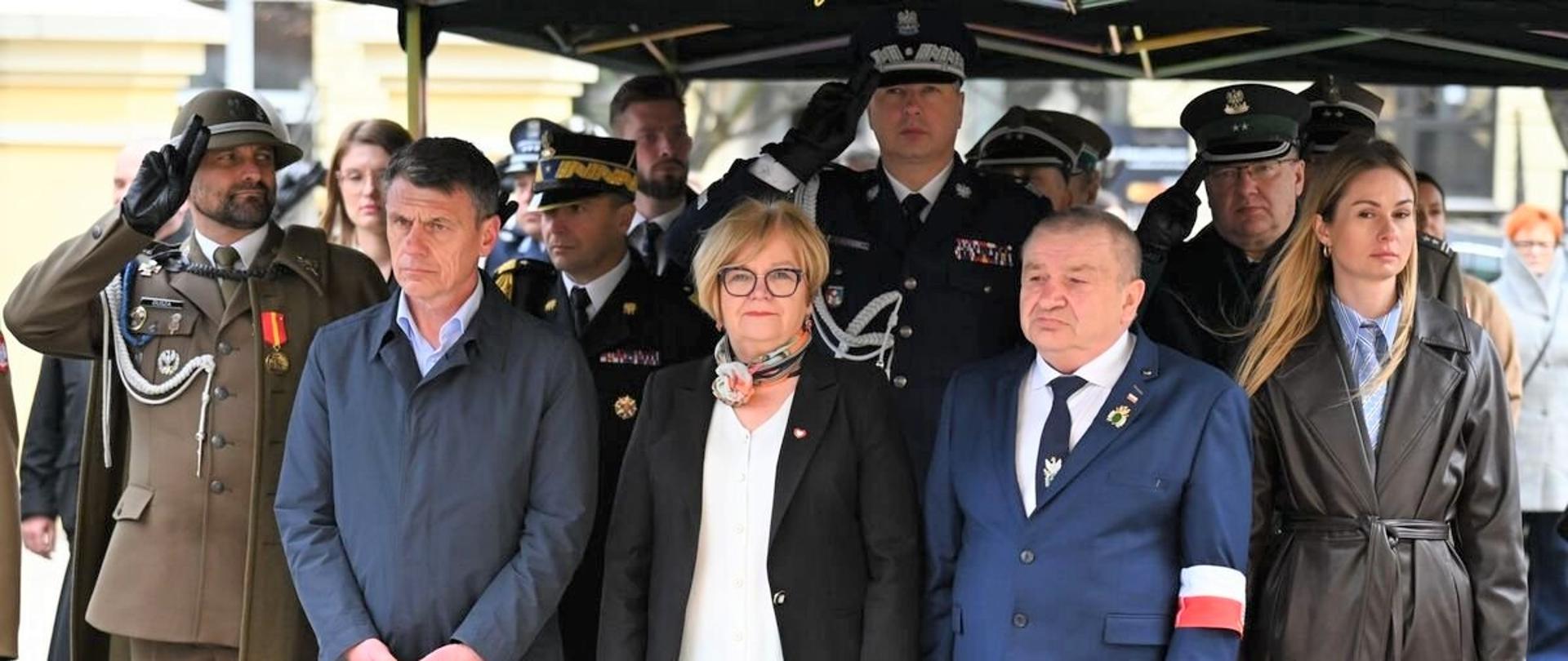 Uczestnicy uroczystości oddają hołd.