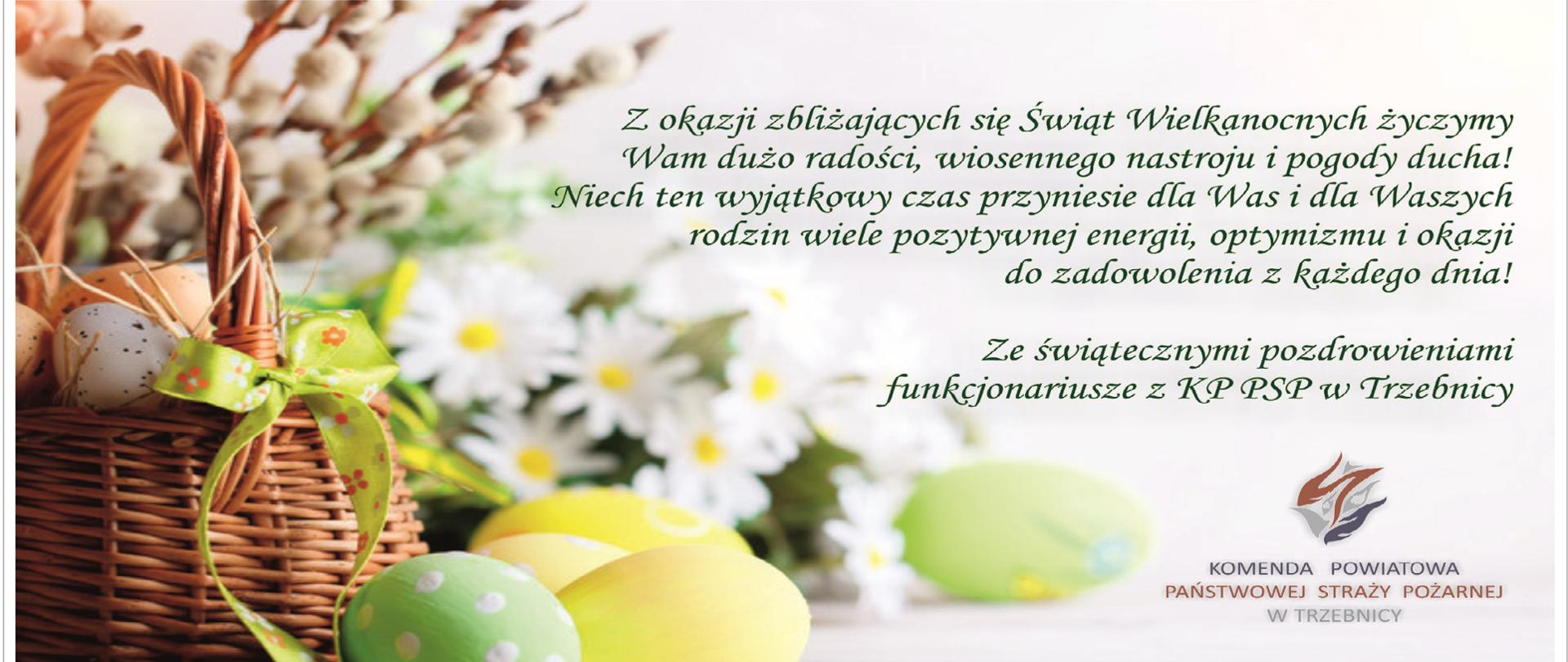 Kartka świąteczna. Po lewej stronie koszyczek wielkanocny wypełniony kolorowymi pisankami. Za nim bazie i bukiet stokrotek. Po prawej stronie napis: z okazji zbliżających się Świąt Wielkanocnych życzymy Wam dużo radości, wiosennego nastroju i pogody ducha! Niech ten wyjątkowy czas przyniesie dla Was i Waszych rodzin, wiele pozytywnej energii, optymizmu i okazji do zadowolenia z każdego dnia! Ze świątecznymi pozdrowieniami funkcjonariusze z KP PSP w Trzebnicy
