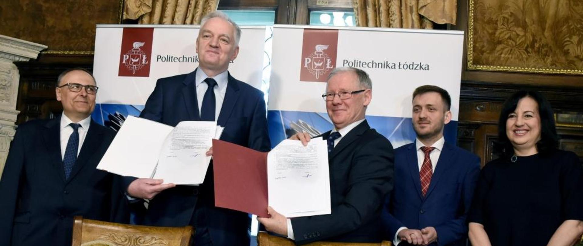 Członkowie władz uczelni i minister Gowin pokazują podpisane umowy