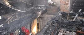 Na zdjęciu widać wnętrze budynku po pożarze. Konstrukcja dachu oraz stropu jest całkowicie zwęglona, widoczne są zniszczone i nadpalone elementy drewniane oraz zadymienie. W tle widać murowany przewód kominowy, prawdopodobnie będący źródłem zapłonu.
Pożar jest wynikiem rażących zaniedbań ze strony użytkownika — brak właściwego utrzymania przewodu kominowego i instalacji grzewczej doprowadził do przegrzania i zapalenia elementów konstrukcyjnych budynku.