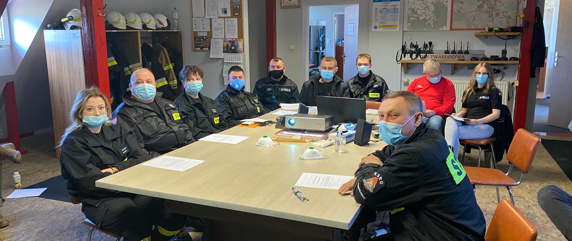 Na zdjęciu strażacy siedzą przy stole