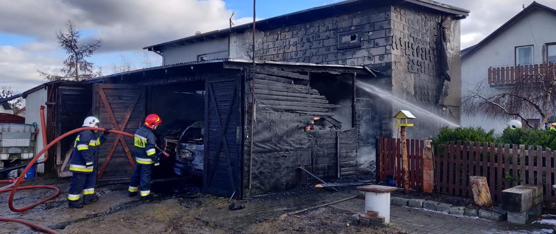 Strażacy podający prąd wody w natarciu