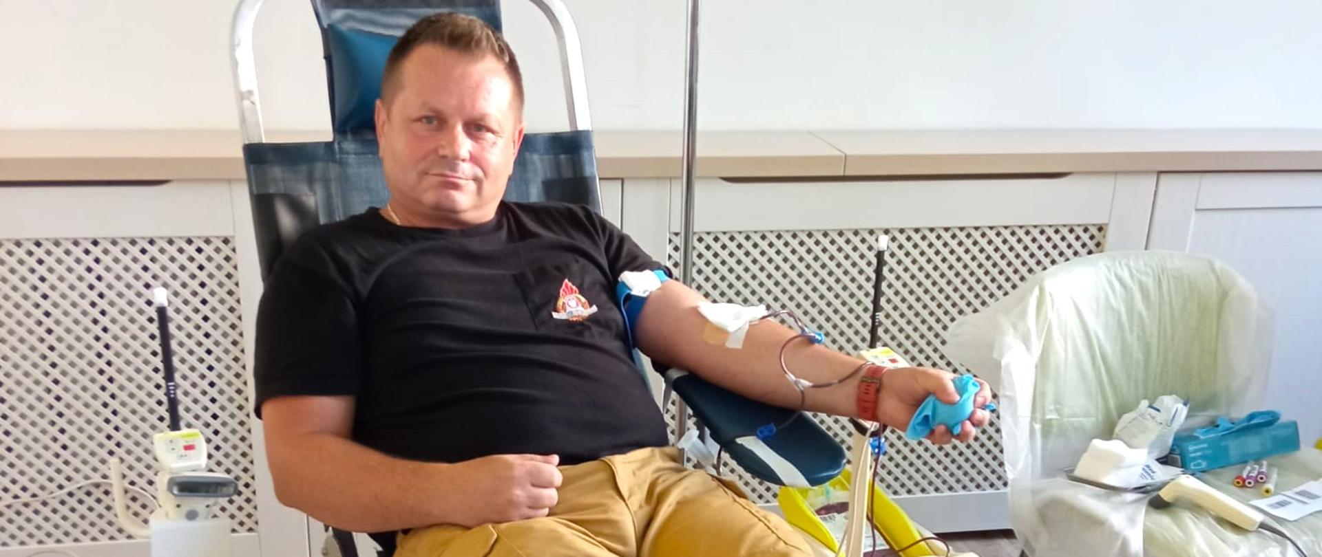 Zdjęcie przedstawia st. kpt. Bogdana Mielnik, funkcjonariusza Komendy Powiatowej Państwowej Straży Pożarnej w Gołdapi w momencie oddawania krwi w ramach akcji krwiodawstwa