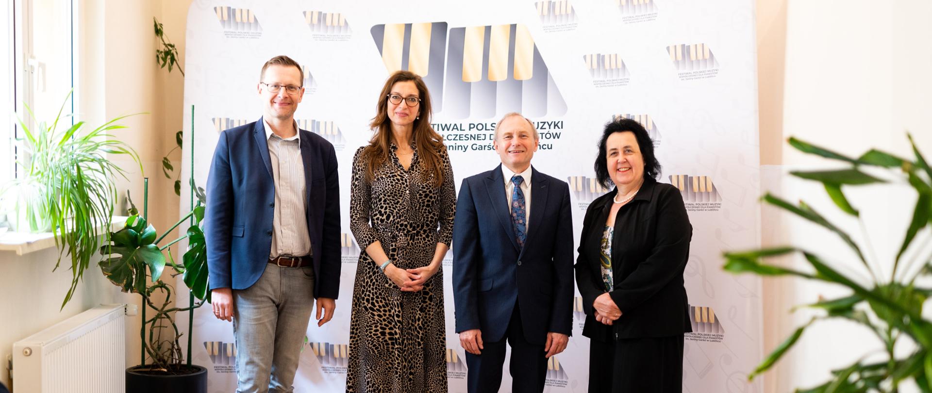 Jury Festiwalu na tle ścianki z logiem festiwalu.