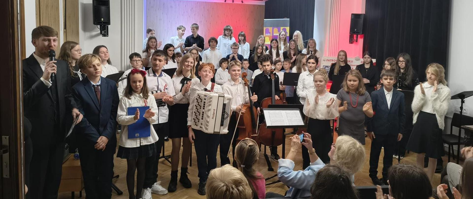 Galeria 16 zdjęć z koncertu z muzyka polską z okazji Święta Odzyskania Niepodległości, który odbył się 05 listopada 2025 w PSM w Kłodzku. Uczniowie grają na instrumentach w sali koncertowej.
