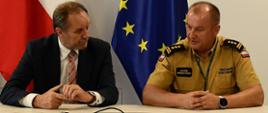 Przy stole siedzą: Marszałek województwa pomorskiego Mieczysław Struk oraz Pomorski Komendant Wojewódzki st. bryg. Jacek Niewęgłowski