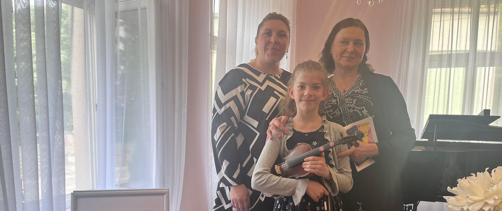Zdjęcie portretowe p. Iryny Yakymets, p. Krystyny Ślęzak wraz z uczennicą Mają Zabłocką trzymającą skrzypce