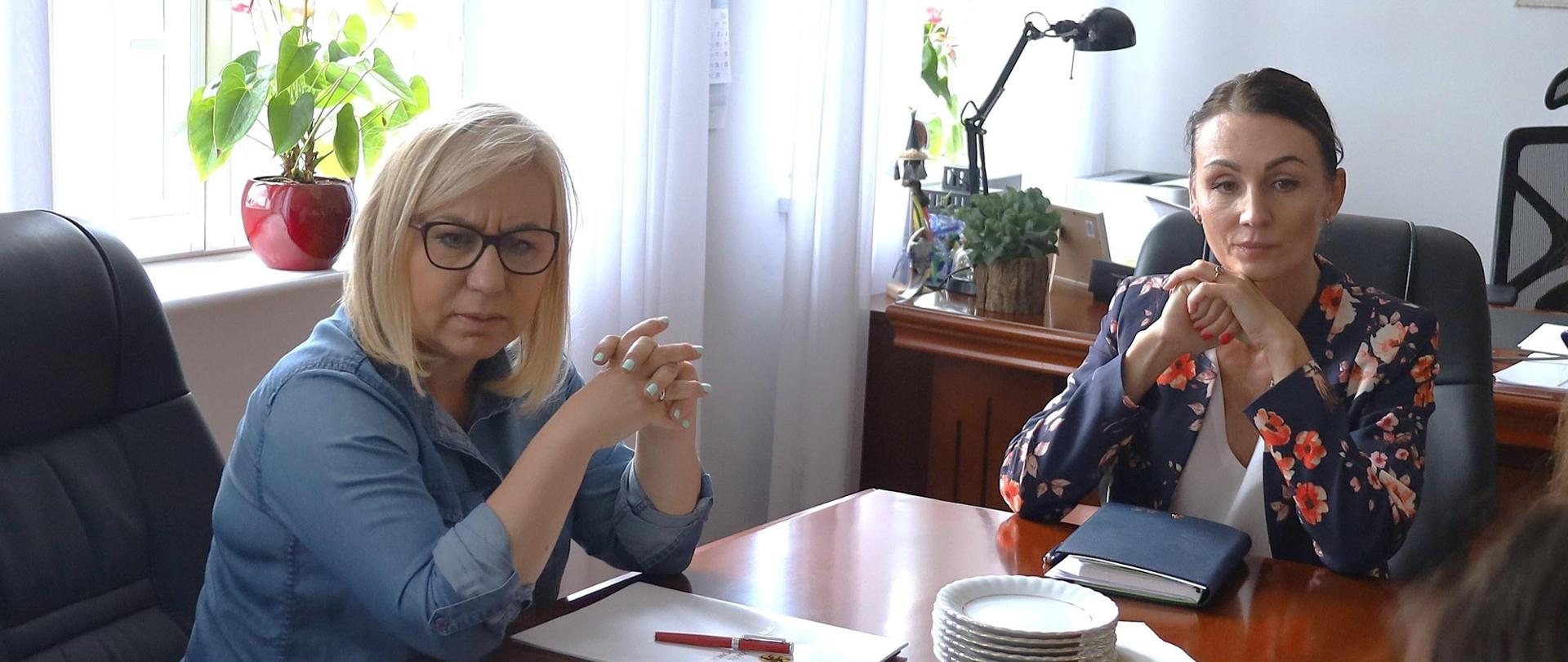 dwie kobiety - minister i wojewoda siedzą przy stole i rozmawiają