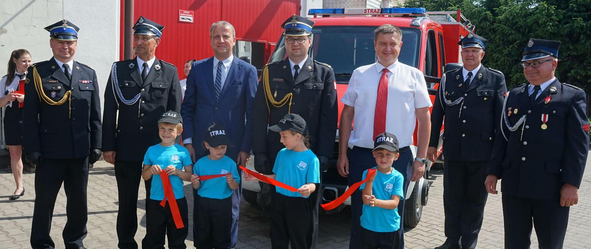 Zdjęcie grupowe zaproszonych gości. W pierwszym rzędzie stoją dzieci z MDP.