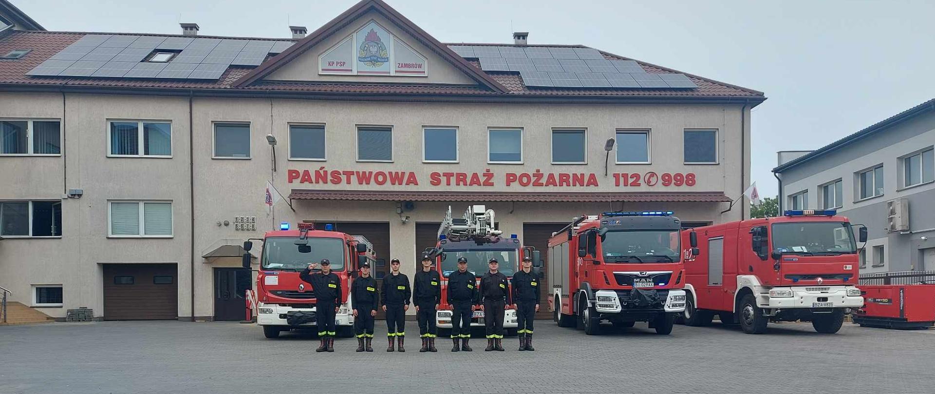 Strażacy podczas upamiętnienie a 79 rocznicy Powstania Warszawskiego, w tle garaż JRG.
