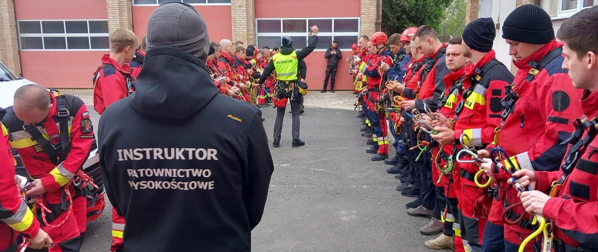 Strażacy z grupy wysokościowej stoją w dwurzędzie.